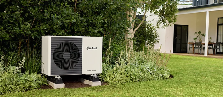 Pompe à chaleur Vaillant aroTHERM Split plus dans un jardin, devant une maison